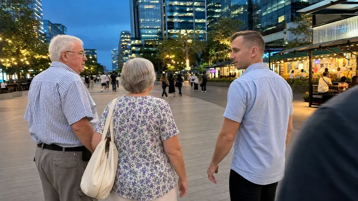 Valery and a couple walking through IT Park in the evening