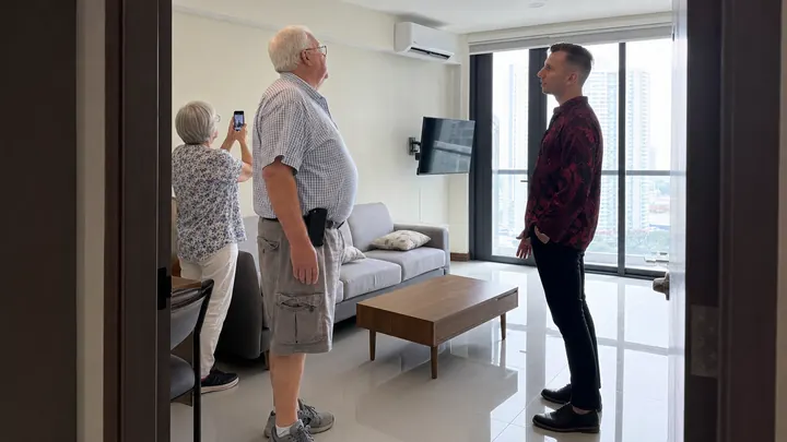 Valery showing a retired couple around a bright living room