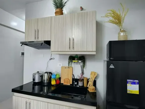 A compact kitchen corner with a fridge and a two-ring stove