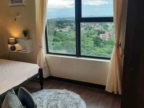 A bedroom with a big window over the city