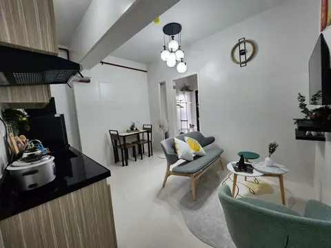 A furnished one-bedroom living area in light wood and grey