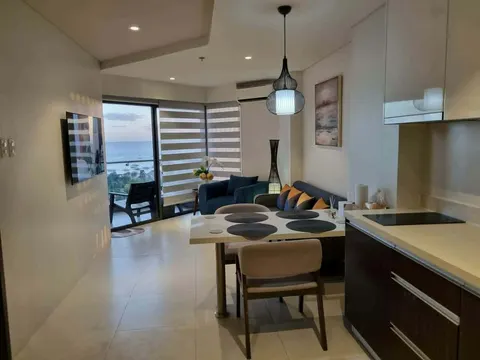 A modern lounge with a dining table and a city view